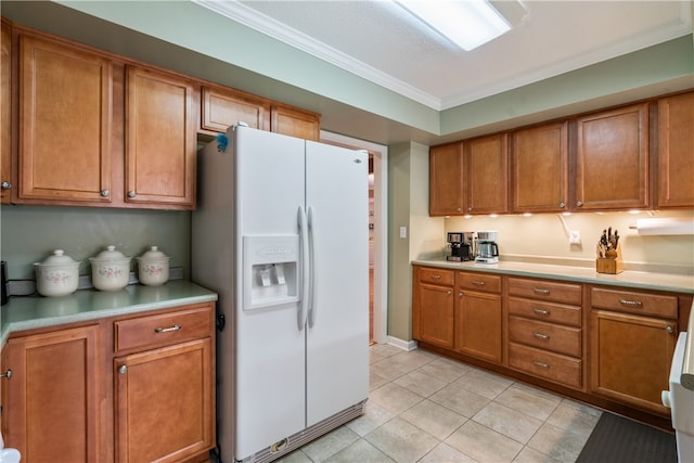 kitchen with light tile patterned flooring, white fridge with ice dispenser, and ornamental molding