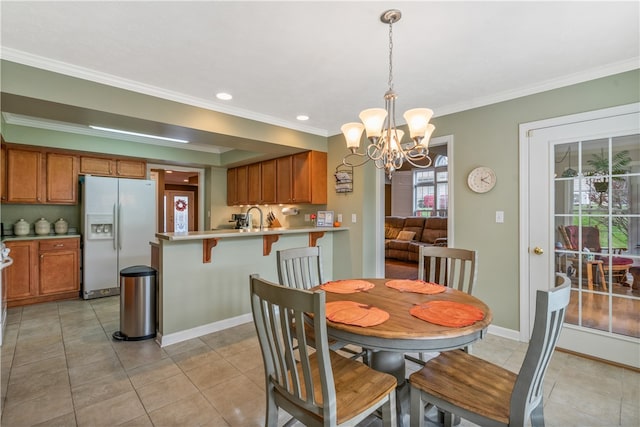 dining area featuring ornamental molding, a notable chandelier, and light tile patterned floors