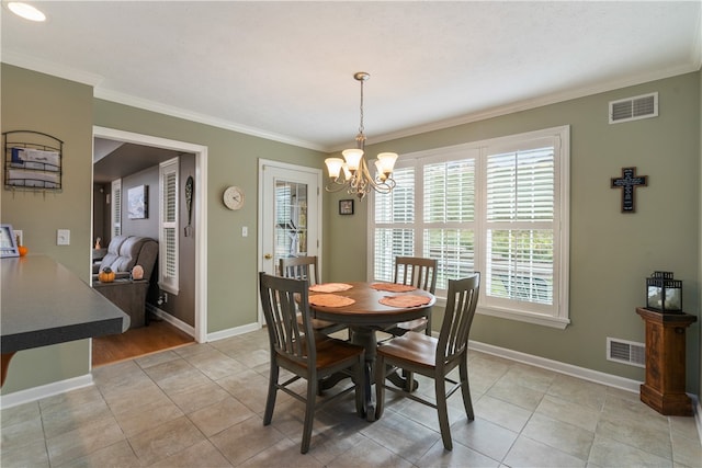 tiled dining area featuring an inviting chandelier and ornamental molding