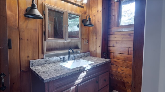 bathroom featuring vanity and wooden walls