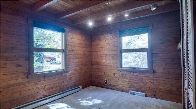 unfurnished room with plenty of natural light, wood ceiling, wooden walls, and a baseboard heating unit