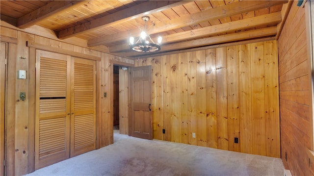 interior space featuring a chandelier, wood ceiling, wooden walls, and beam ceiling