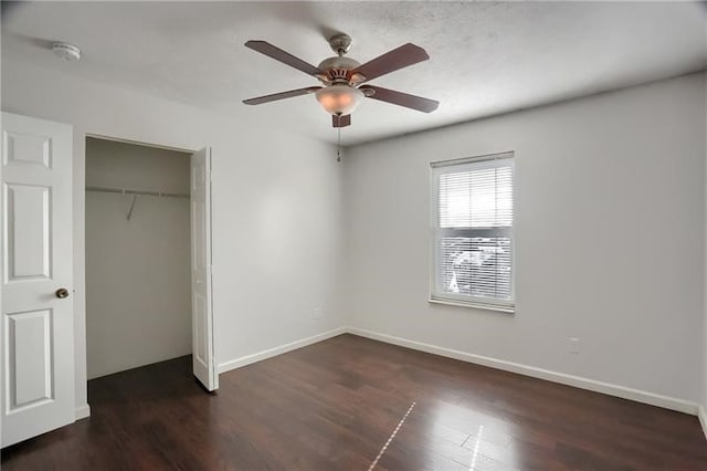 unfurnished bedroom with dark wood-type flooring, ceiling fan, and a closet