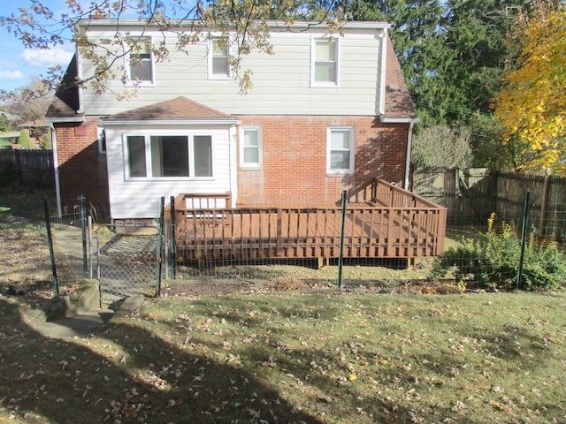 rear view of house featuring a yard and a wooden deck