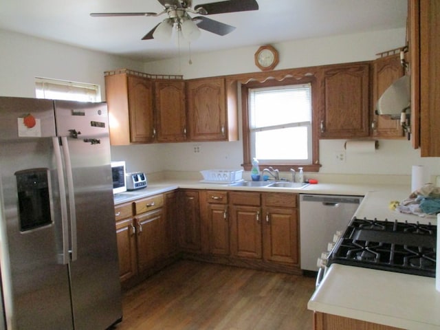 kitchen featuring stainless steel appliances, hardwood / wood-style flooring, extractor fan, sink, and ceiling fan