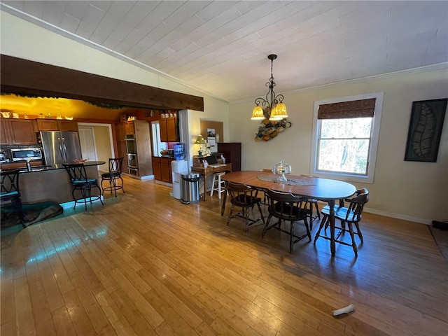 dining space with an inviting chandelier, crown molding, light hardwood / wood-style flooring, and lofted ceiling