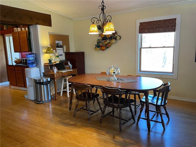 dining room featuring light wood-type flooring, lofted ceiling, and ornamental molding