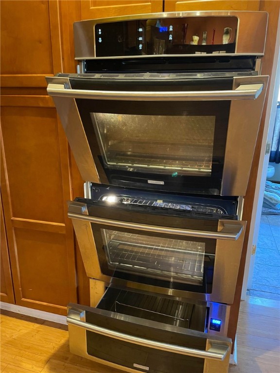 interior details featuring light wood-type flooring and double oven