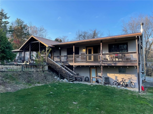 back of property featuring a lawn and a deck