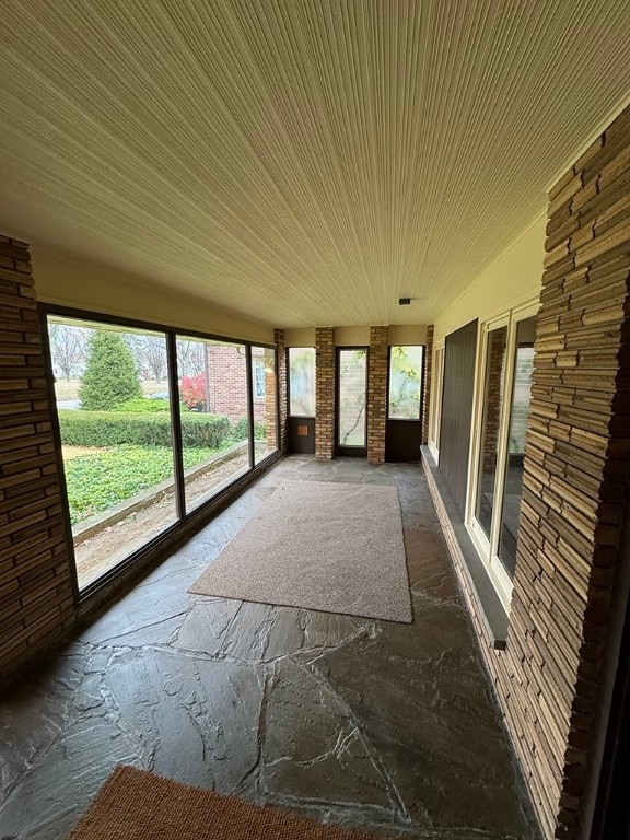 unfurnished sunroom featuring vaulted ceiling