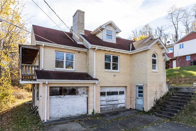 back of property featuring a garage and a balcony