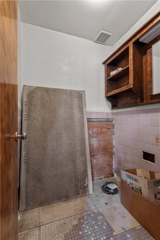 bathroom featuring tile patterned floors and tile walls