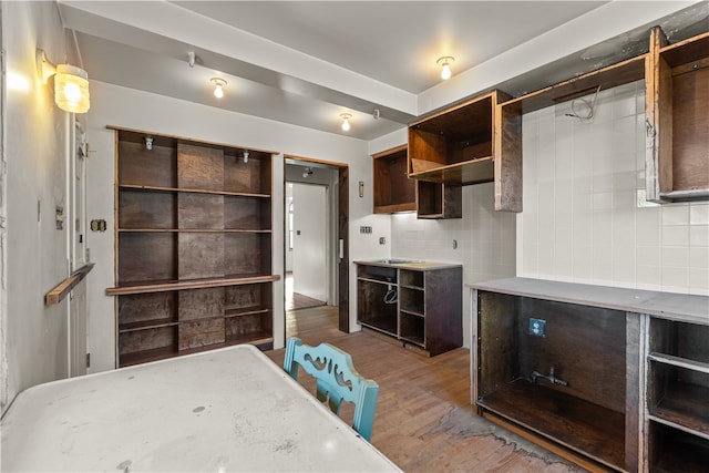 kitchen featuring hardwood / wood-style floors, dark brown cabinetry, and backsplash