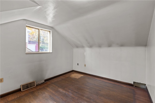 bonus room with dark wood-type flooring and vaulted ceiling