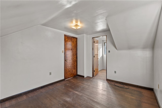 additional living space with dark hardwood / wood-style floors and vaulted ceiling