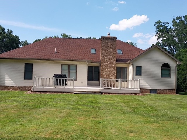 back of property with a wooden deck and a yard