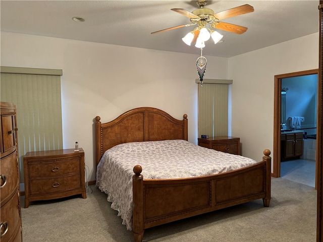 bedroom featuring light carpet, connected bathroom, and ceiling fan