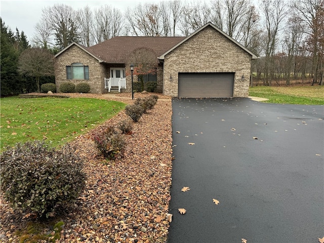 ranch-style house featuring a front yard and a garage