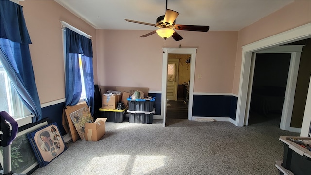 living area with carpet and ceiling fan