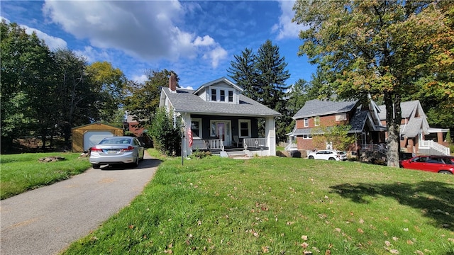 view of front of home featuring a front lawn, a garage, and covered porch