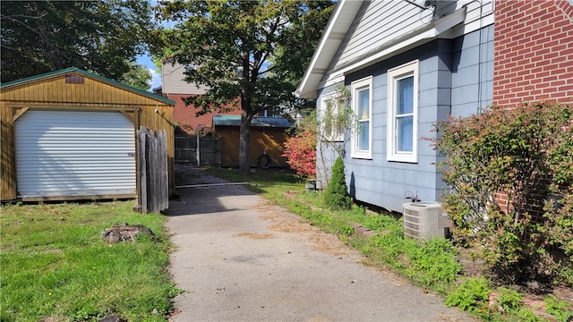 view of property exterior with an outbuilding, a garage, and central AC unit