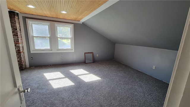 additional living space with wood ceiling, vaulted ceiling, and carpet floors