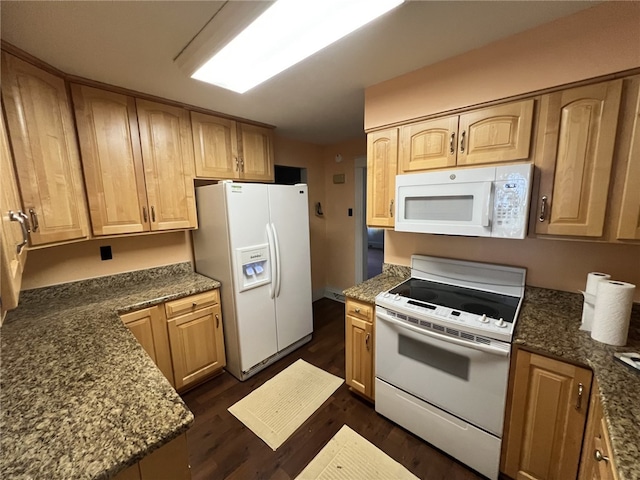 kitchen with dark wood-type flooring, dark stone counters, and white appliances