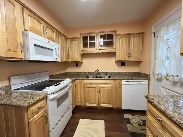 kitchen featuring dark stone counters, white appliances, dark hardwood / wood-style floors, and sink