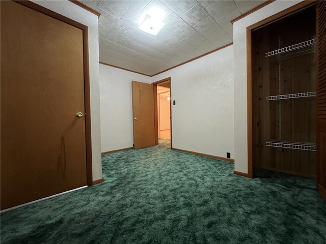 unfurnished bedroom featuring dark colored carpet, a closet, and crown molding