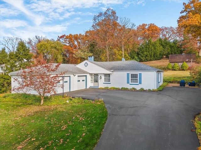 single story home featuring a garage and a front yard