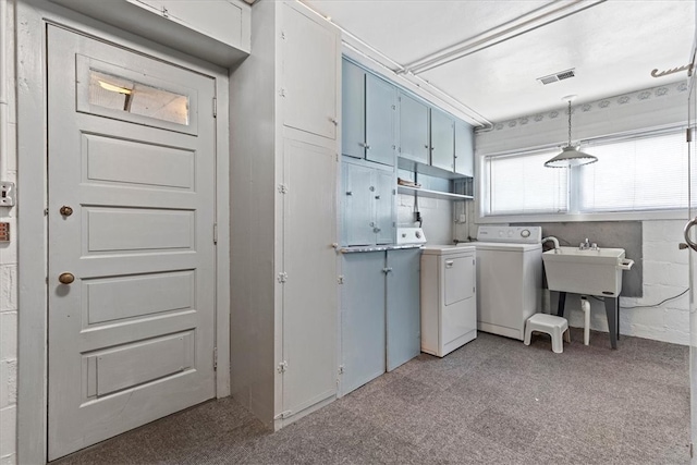 laundry area featuring cabinets, washing machine and clothes dryer, and light carpet