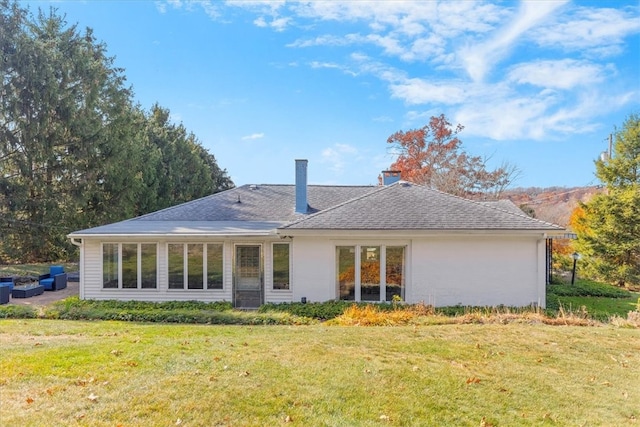 rear view of property featuring a lawn