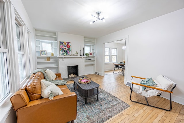 living room featuring a brick fireplace and light hardwood / wood-style flooring