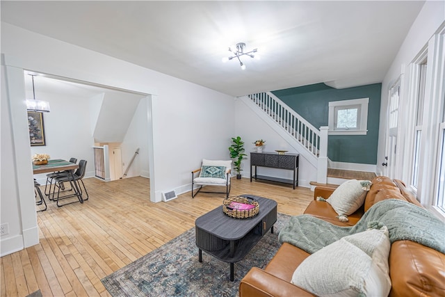 living room with hardwood / wood-style floors and a notable chandelier