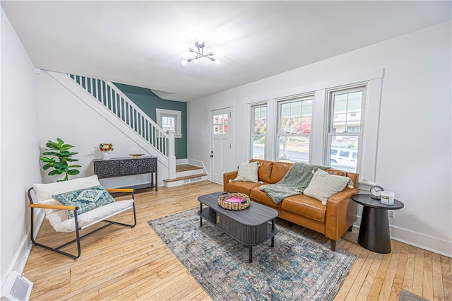 living room with hardwood / wood-style floors and a notable chandelier