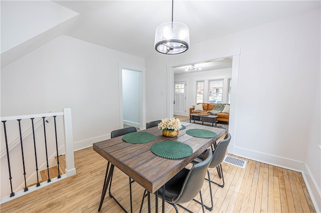 dining room featuring light hardwood / wood-style flooring and a notable chandelier