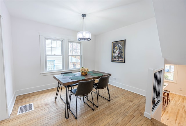 dining space featuring light hardwood / wood-style floors and a notable chandelier