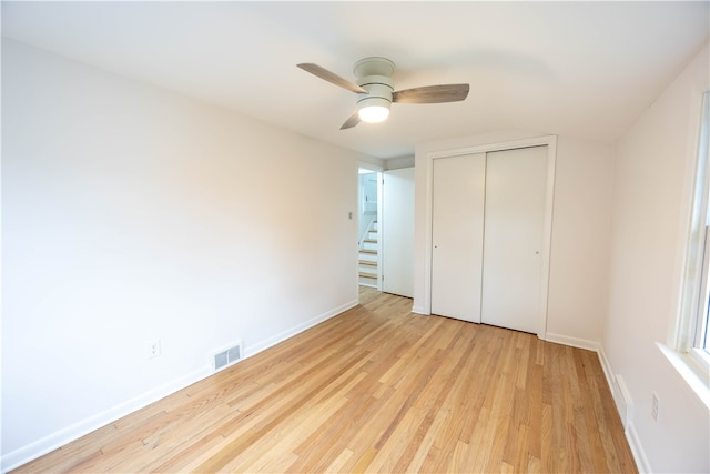 unfurnished bedroom featuring a closet, light wood-type flooring, and ceiling fan