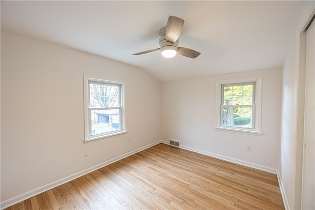 empty room with light hardwood / wood-style flooring, lofted ceiling, and plenty of natural light