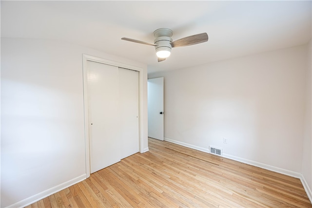 unfurnished bedroom featuring a closet, light wood-type flooring, and ceiling fan