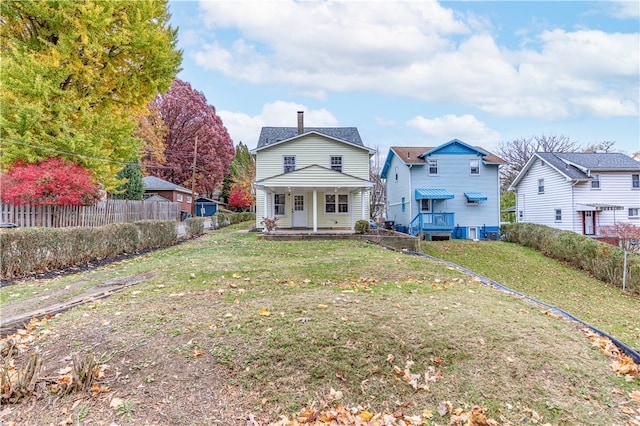 back of house featuring a yard and covered porch