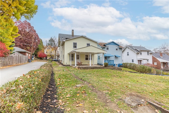 view of front of house with a porch and a front yard