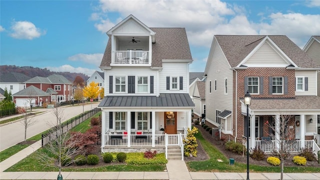 view of front of home with a balcony, ceiling fan, and a porch