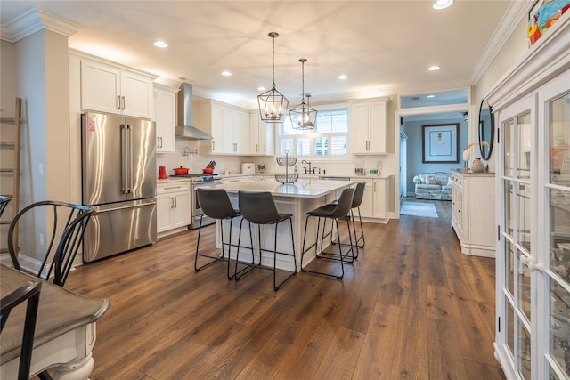 17 Carolina Ave, Oakmont, PA 15139 - kitchen with stainless steel appliances, wall chimney exhaust hood, crown molding, a kitchen breakfast bar, and white cabinetry