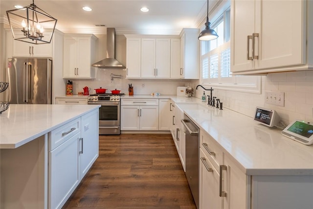 17 Carolina Ave, Oakmont, PA 15139 - kitchen with wall chimney range hood, appliances with stainless steel finishes, white cabinets, a chandelier, and dark wood-type flooring