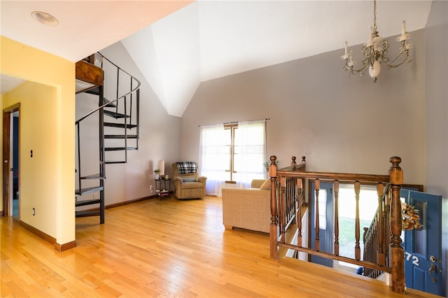 living room featuring hardwood / wood-style floors, a chandelier, and vaulted ceiling