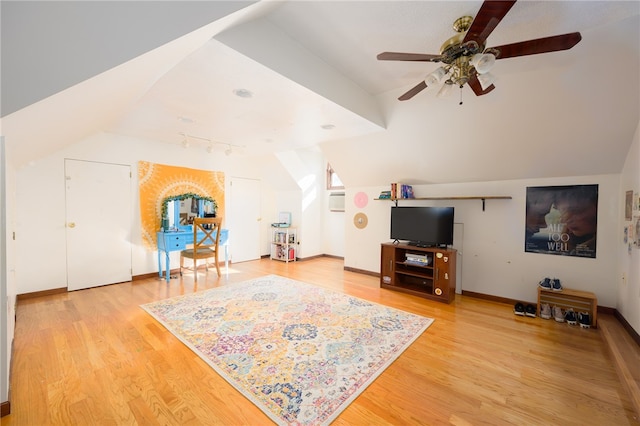 living room with hardwood / wood-style floors, vaulted ceiling, and ceiling fan