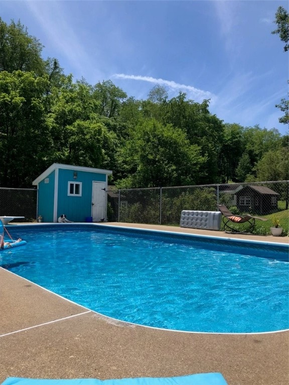 view of swimming pool featuring a shed