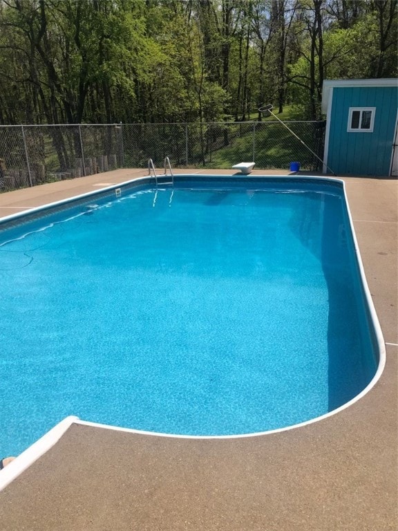 view of pool with a diving board