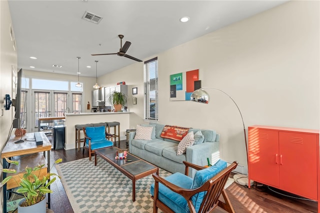 living room with ceiling fan and dark hardwood / wood-style flooring